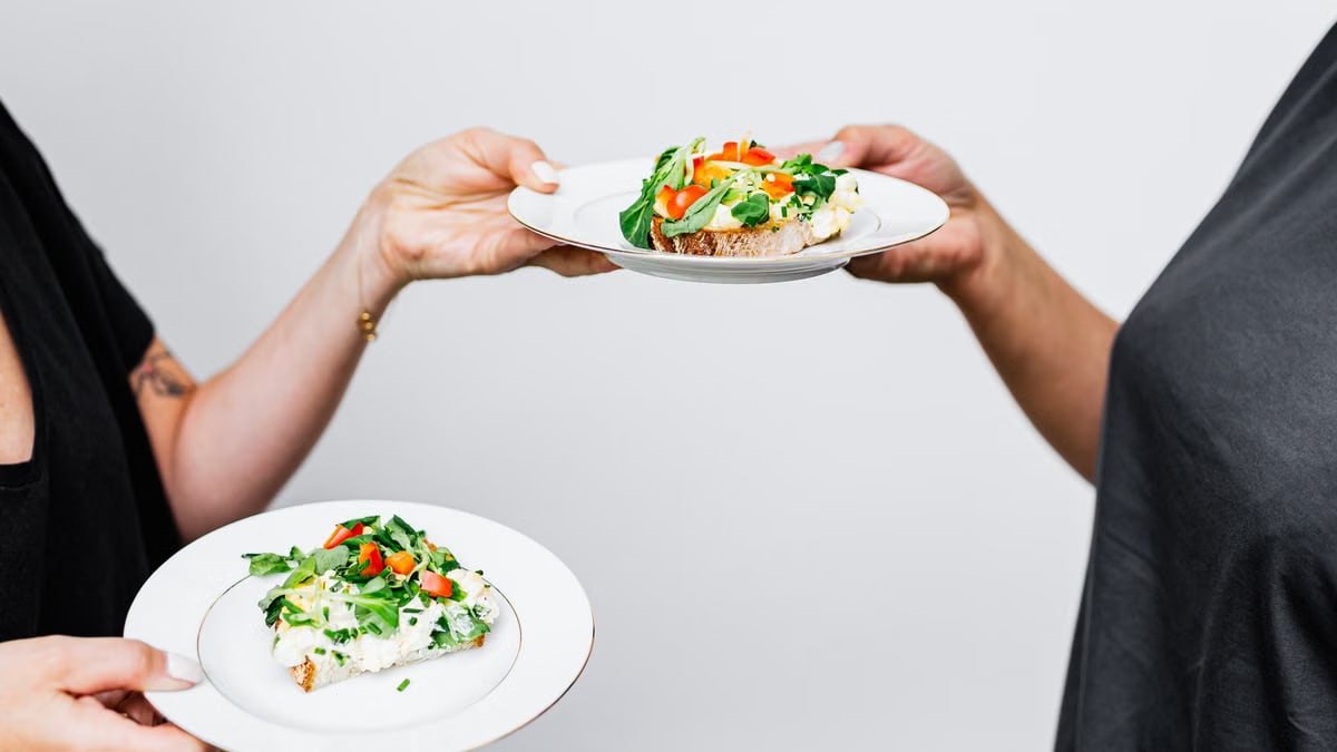 A close-up of two plates with vegetable toast, showcasing fresh ingredients and vibrant colors.